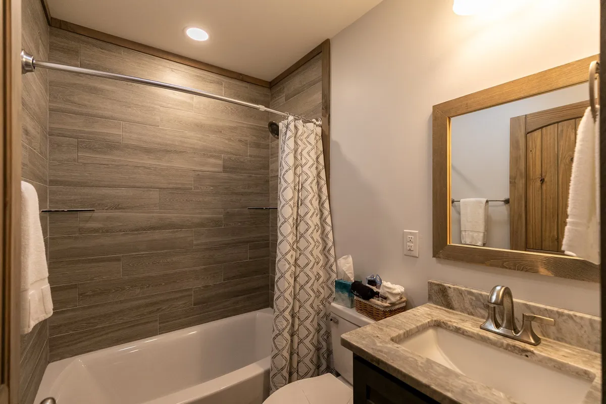 A modern bathroom outfitted with a bathtub, spacious shower area, elegant sink, and soft towels. The space feels spa-like and inviting, perfect for relaxation and self-care.